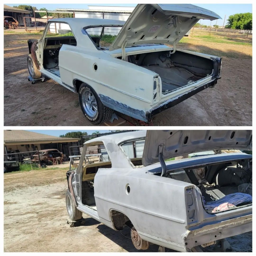 A vintage car undergoing restoration with its doors and trunk open.