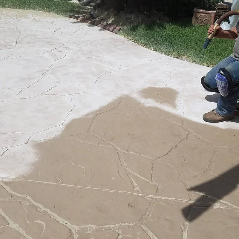 Man kneeling on the ground casting a shadow in sunlight.